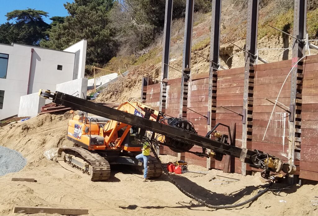 REV Drill rig installing tiebacks on a hillside jobsite